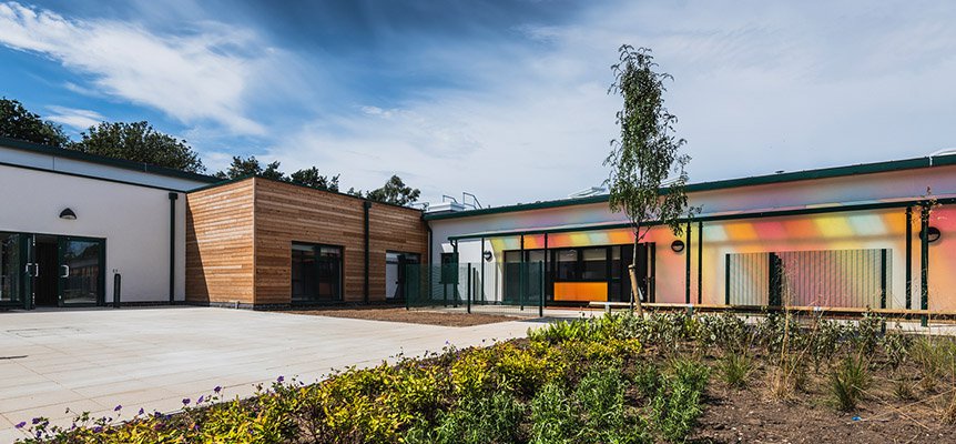 Image of the outside of the The Bridge SEN School, with brightly coloured sun shade to the front of the building