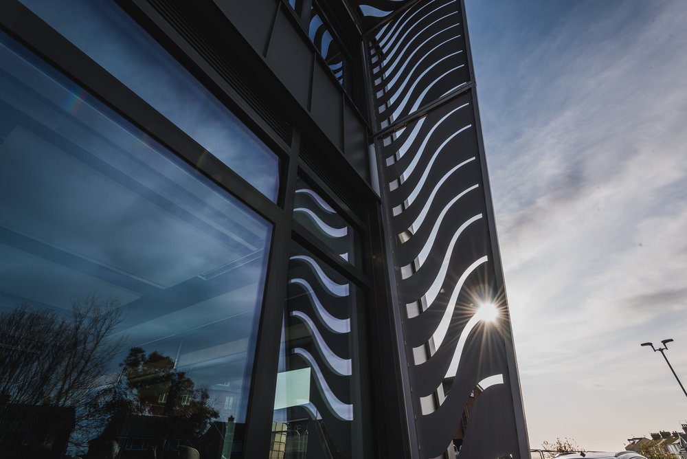 Close up of the glazing on the CEFAS building in Lowestoft and metal panels on the side of the building which are shaped to mimick waves