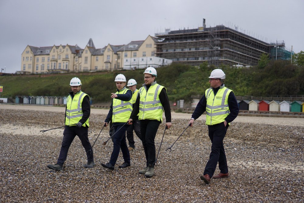 Five members of the Morgan Sindall Construction team in their PPE conducting a litter pick on Lowestoft beach