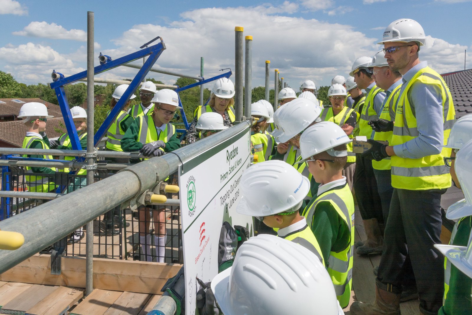 Pupils draw their self portraits on a board provided at the Ryedene School topping out ceremony