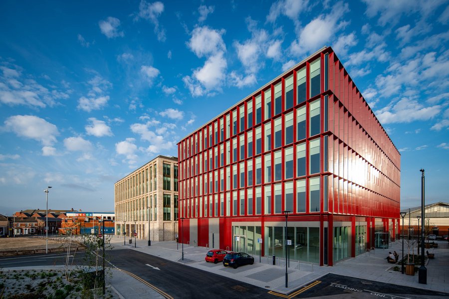 Two office buildings, one with red cladding the other white brickwork