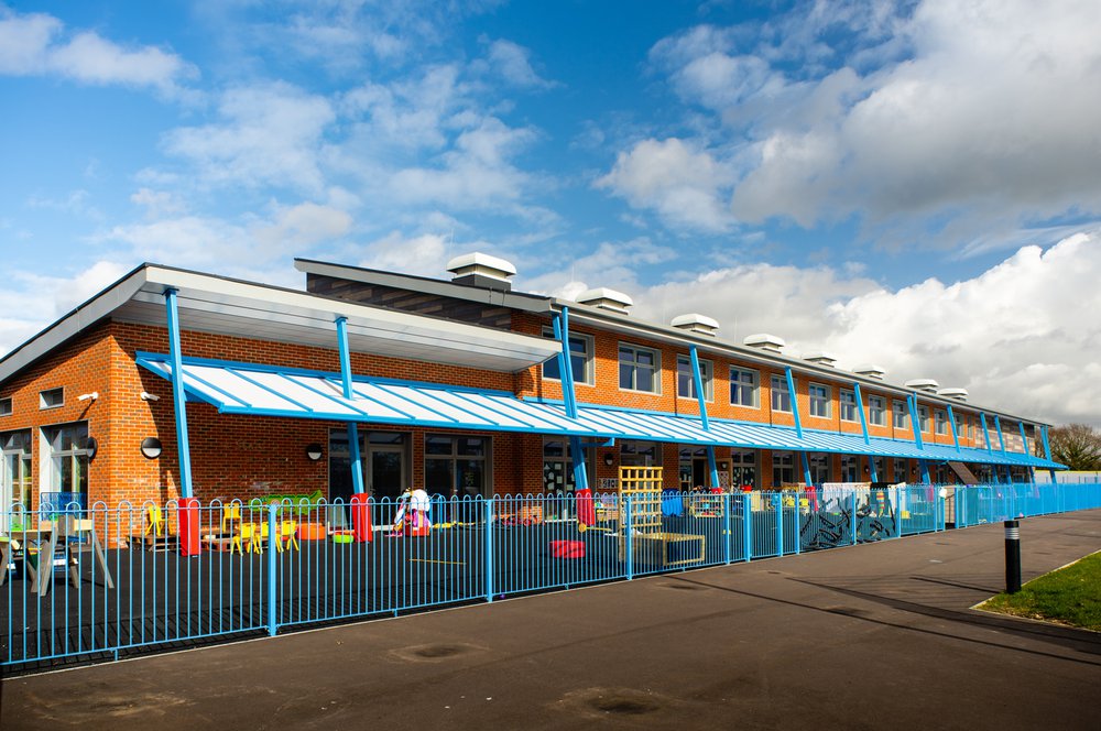 View of the enclosed playground at Hailsham School, with bright blue railings around the outside