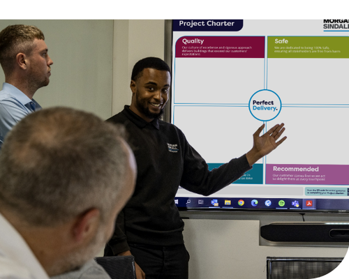 Two male employees giving a presentation on a TV screen