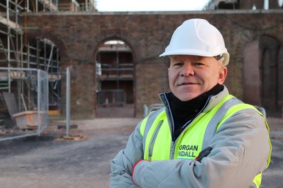 Picture of BBC presenter Dominic Littlewood in high-vis outside the Rugby Radio/Houlton School project