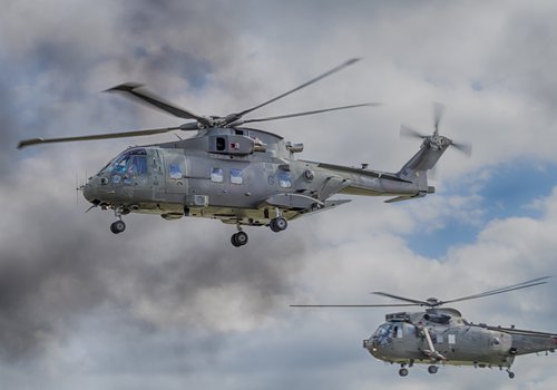 Two army helicopters flying in the sky