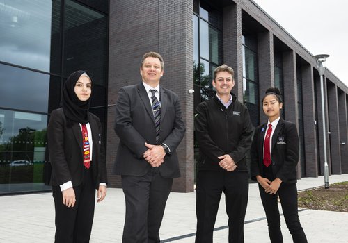 Students from the Co-operative Academy in Manchester outside the front entrance to their new building
