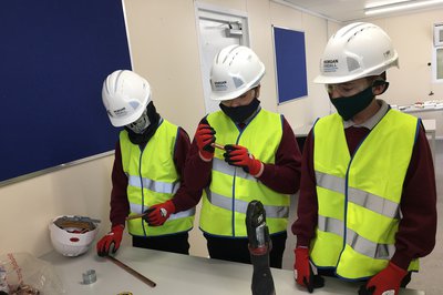 Three students taking part in a construction workshop