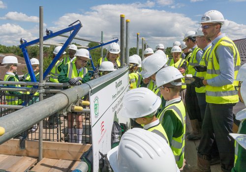 Pupils draw their self portraits on a board provided at the Ryedene School topping out ceremony