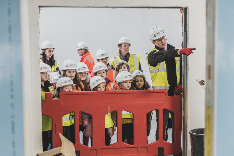 A site tour taking place on a Morgan Sindall Construction site with a group of primary school children and their teachers