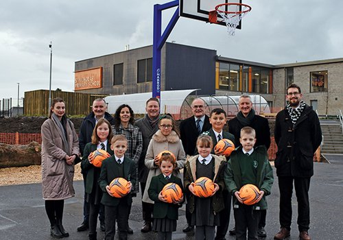 The Morgan Sindall Construction team and teachers and Pupils from St Nicholas' Primary standing on the new basketball court