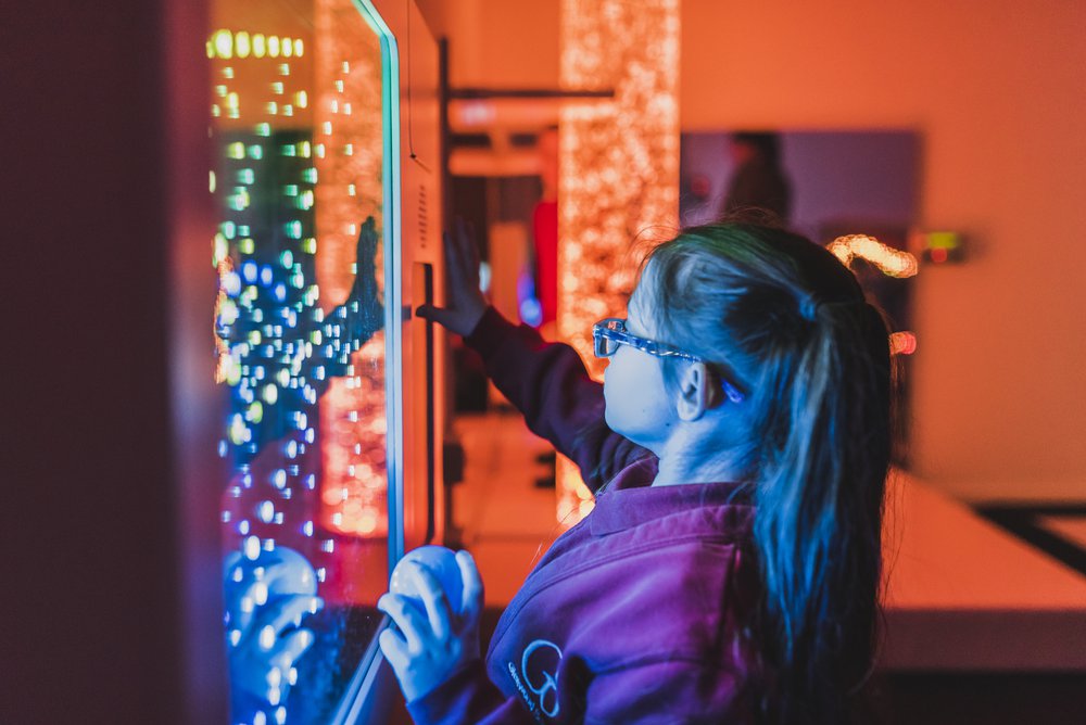 Image of a child in the sensory room at Glenwood SEN School in Essex, she is using one of the sensory bubble machines