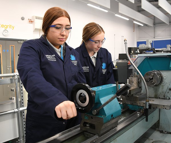 Two students of the Energy Coast UTC are pictured working at an industrial machine