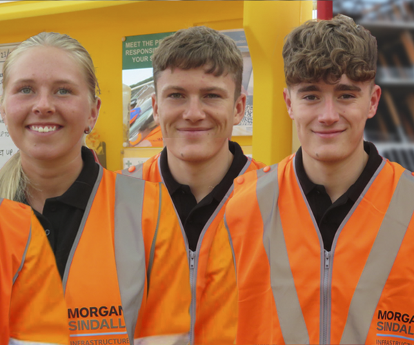 Five Morgan Sindall Infrastructure apprentices stand in a row, smiling, wearing Personal Protective Equipment