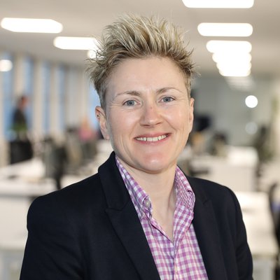 Morgan Sindall Infrastructure's SHEQ Director, Carole Bardell-Wise, is pictured standing in an office, looking at the camera.