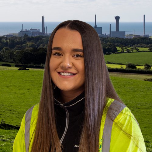A photograph of Morgan Sindall Infrastructure employee Lauren Moore, wearing Personal Protective Equipment and smiling at the camera
