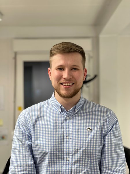 Morgan Sindall Infrastructure colleague Lee Rossiter sits in an office environment, smiling at the camera