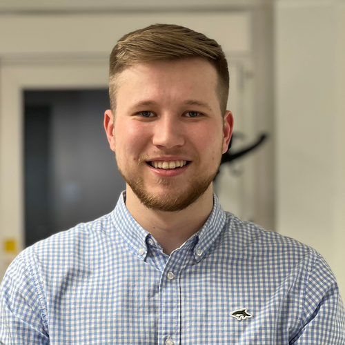 Morgan Sindall Infrastructure colleague Lee Rossiter sits in an office environment, smiling at the camera