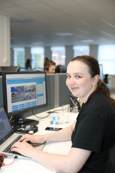 Morgan Sindall Infrastructure colleague Lucy Thomson sits at her desk, smiling at the camera