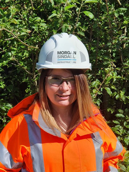 Morgan Sindall Infrastructure colleague Michelle Russ stands wearing Personal Protective Equipment, looking into the camera