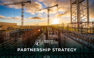 A photograph of work taking place on site - scaffolding is visible in the foreground, and colleagues wearing Personal Protective Equipment, with two cranes standing towards the background.